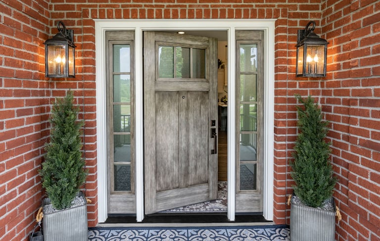 a front door with a brick wall and a potted planter