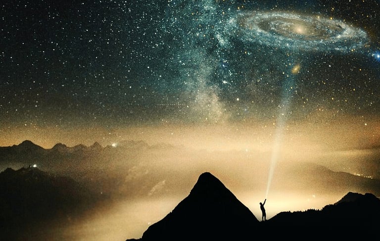 a person standing on a mountain top with a view of a galaxy