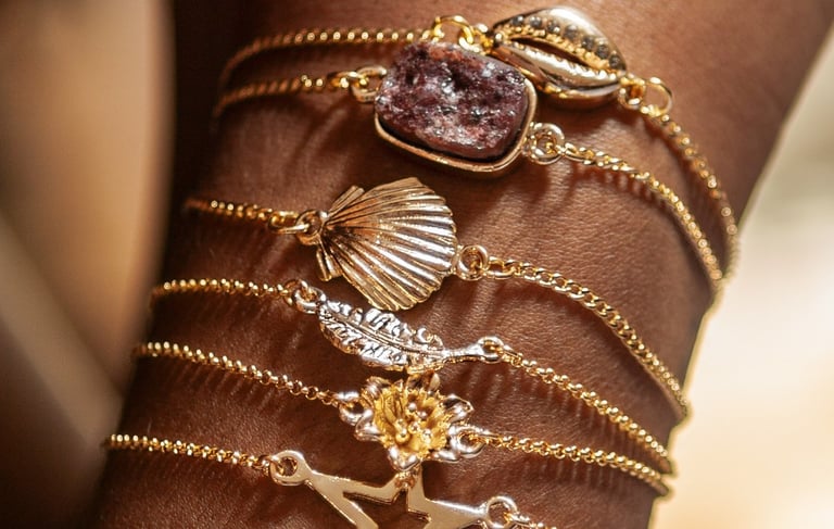 o braço de uma mulher com pulseiras pratas e douradas.