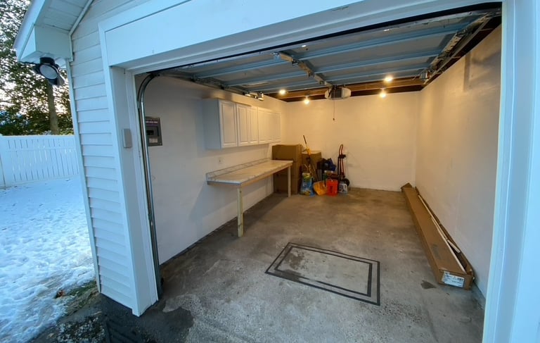 garage with white siding and cabinets with work bench Collingswood, NJ by Golden Rule Construction