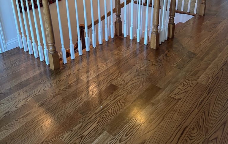 a staircase way with a hardwood floor and a wooden railing