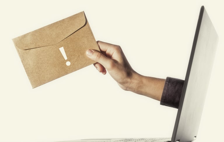 Main tendant une enveloppe kraft depuis un écran d'ordinateur — inscrivez-vous à l'infolettre Marion Communication