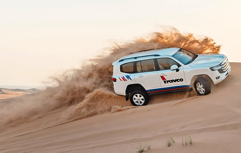 a white suv driving through a desert