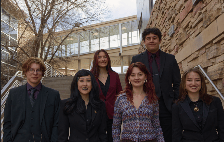 Image of Quesada-Stoner Gregg team standing on a stairwell outdoor by each other.