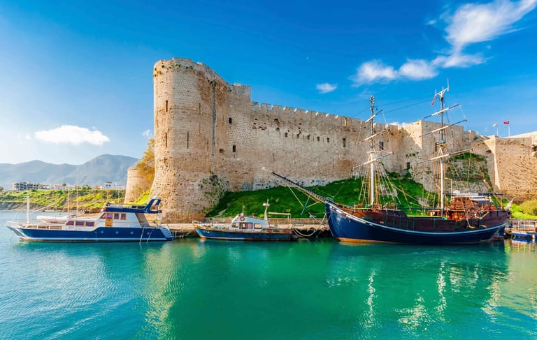 Historic Kyrenia Castle and wooden sailboats in the turquoise water of the old harbor in Northern Cyprus.