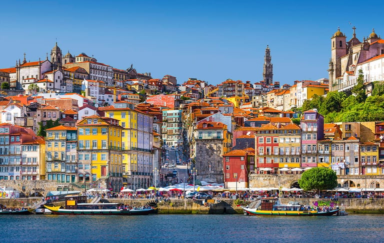 Colorful Ribeira district buildings and Rabelo boats on the Douro River in Porto, Portugal.