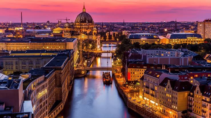 Berlin Cathedral and Spree River at sunset with a panoramic city skyline view in Germany.