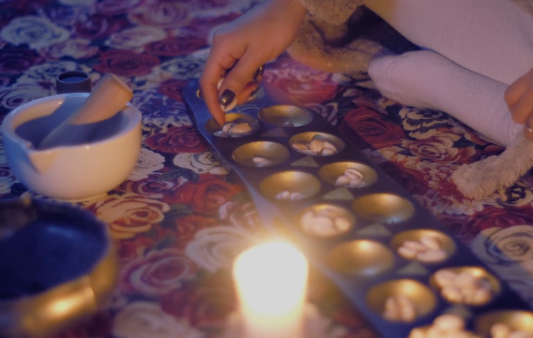 a close up of sungka divination tool game with a woman's hand moving shells