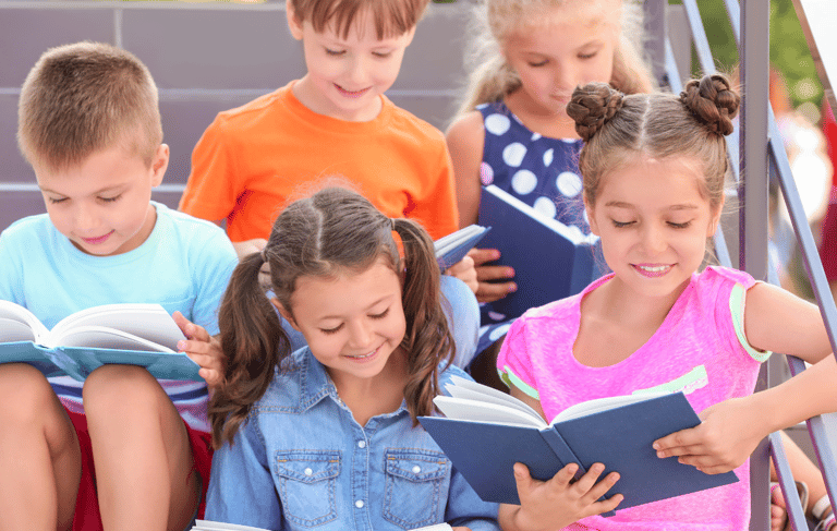 a group of children reading books on stairs