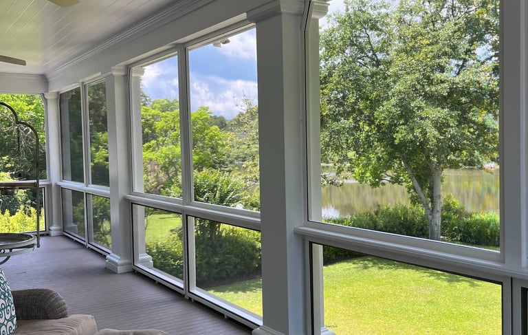 A beautiful screen porch with a couch and a table in James Island.