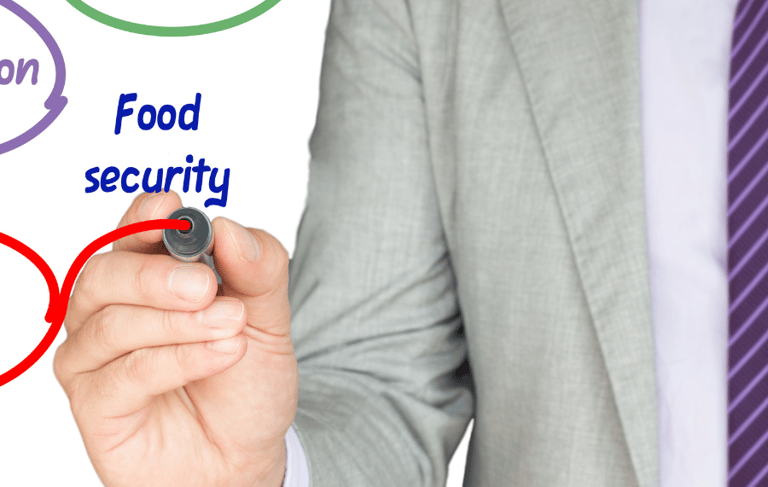 a man in a suit and tie is writing on a white board