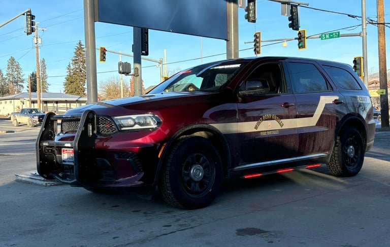 A maroon West Bend-Greeley Fire District chief vehicle, a Dodge Durango with a push bar, parked at a street intersection.