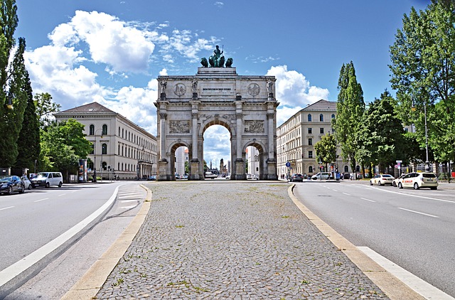 A large archway in a city street framing a clear blue sky.