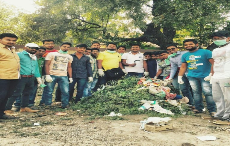 a group of people standing around a pile of garbage
