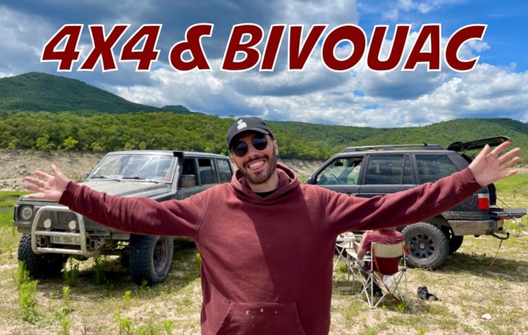un homme les bras écartés devant deux voitures et un paysage naturel