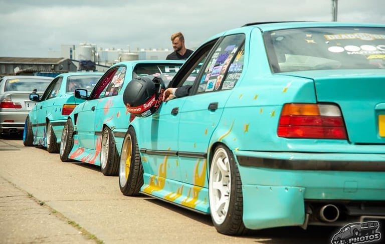 a man in a helmet is sitting in a row of parked cars