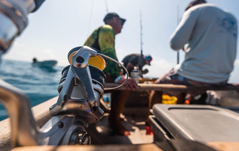 A close-up of fishing gear, including rods, reels, and bait, on a boat in Zanzibar.