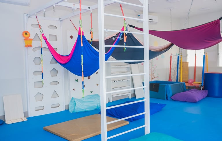 Espaço lúdico e pedagógico da Clínica Integrar 2, com piso macio e equipamentos de estímulos