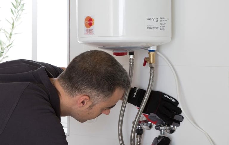 a man in a black shirt is fixing a tankless water heater
