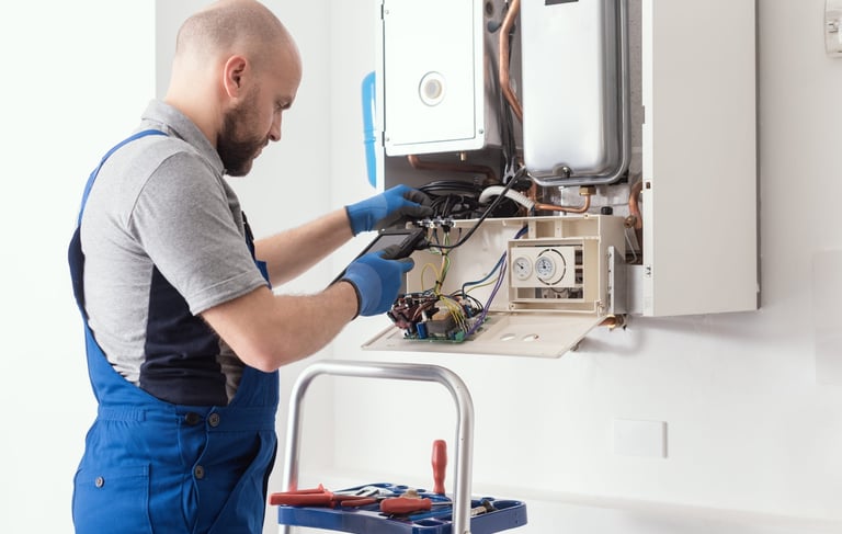 a man in overalls and overalls working on a gas stove