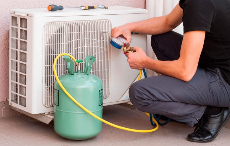 a man in a black shirt is using a hose to fix a gaskettle