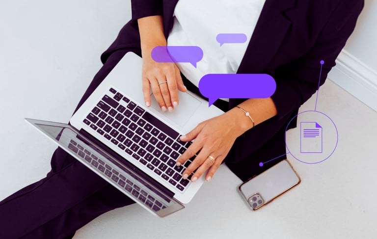 An overhead shot of a female professional with laptop and phone on her lap as she works.