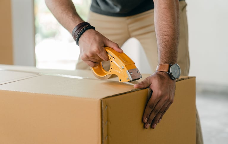 Man packing a product into a cardboard box.