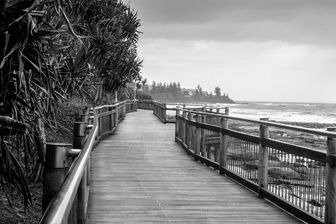 a wooden boardwalk and a view of the ocean in Caloundra