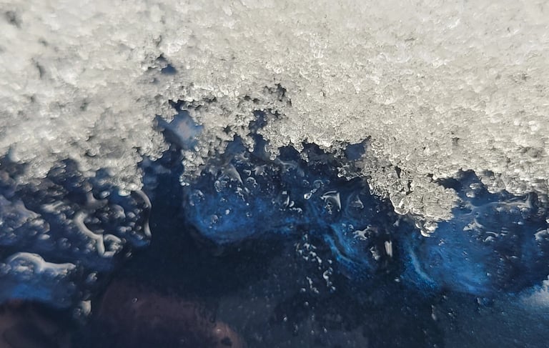 close up picture of ice melting off a blue metal surface