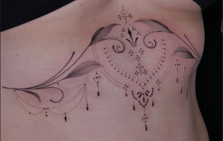 Elegant ornamental sternum tattoo with fine line mandalas, hanging beads, and botanical leaf details.