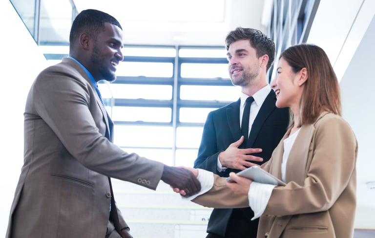 Business professionals shaking hands and referring one another