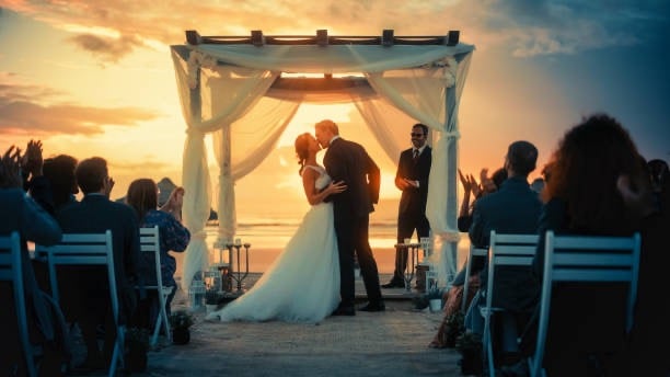 preciso de uma imagem de um casamento, onde apareça a noiva e o noivo, em um por do sol, faça 