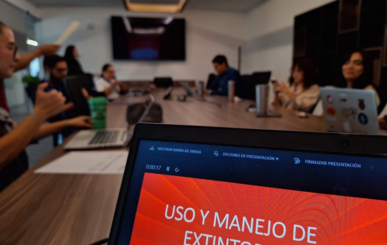 Professional team attending a fire extinguisher safety training presentation in a modern office conference room.