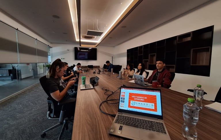 Professional team working on laptops in a modern conference room for a fire safety training session.