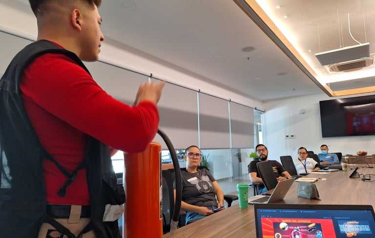 Professional fire safety instructor demonstrates fire extinguisher use to office employees during a training seminar.