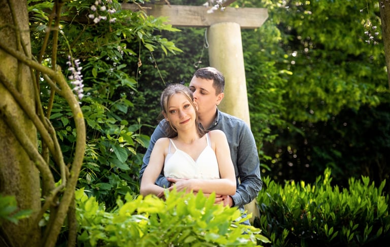 Portrait d'un couple s'étreignant devant une structure en bois avec fleurs