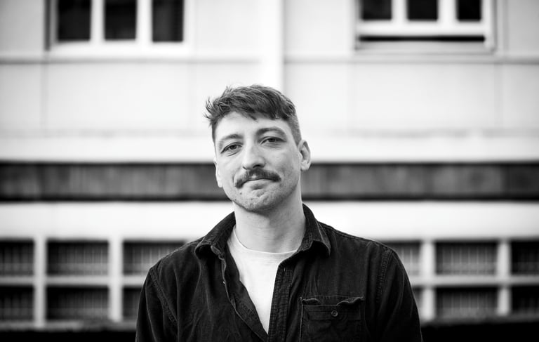 Portrait noir et blanc d'un homme avec une moustache dans un décor urbain