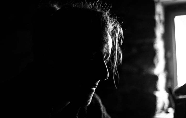 Portrait noir et blanc d'une personne devant une fenêtre