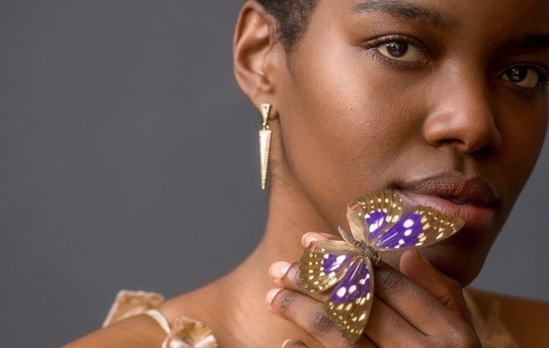 Portrait of woman holding a purple butterfly 