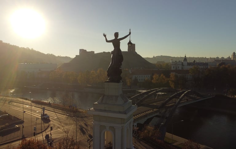 Saulė šviečia į energetikos muziejų Vilniuje, Gedimino pilis tolumoje, drono fotografija