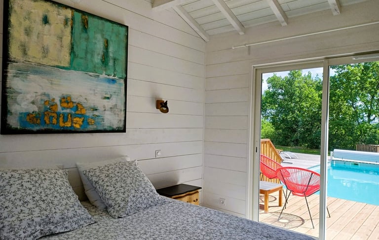 a bedroom with a large bed and a pool in the background Maison Les Terrasses Master suite