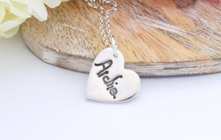 Your childs name, written by them, pressed onto a silver heart pendant