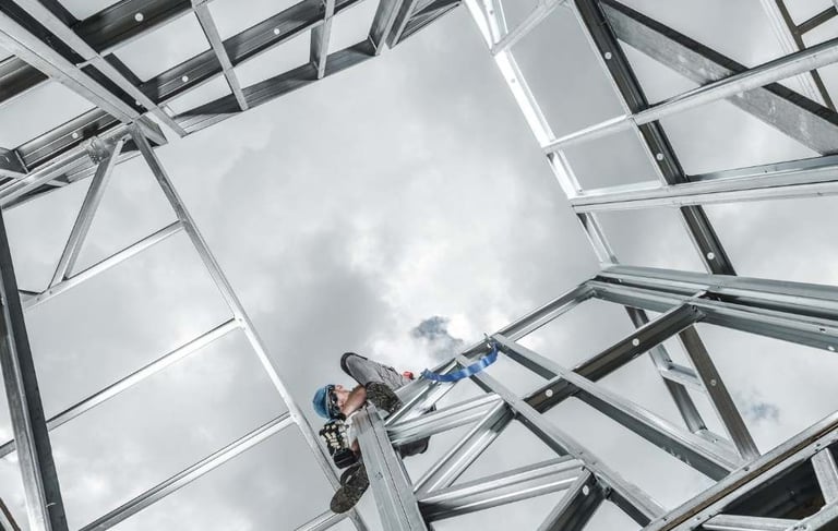 a man on a ladder with a ladder in the middle of a metal structure