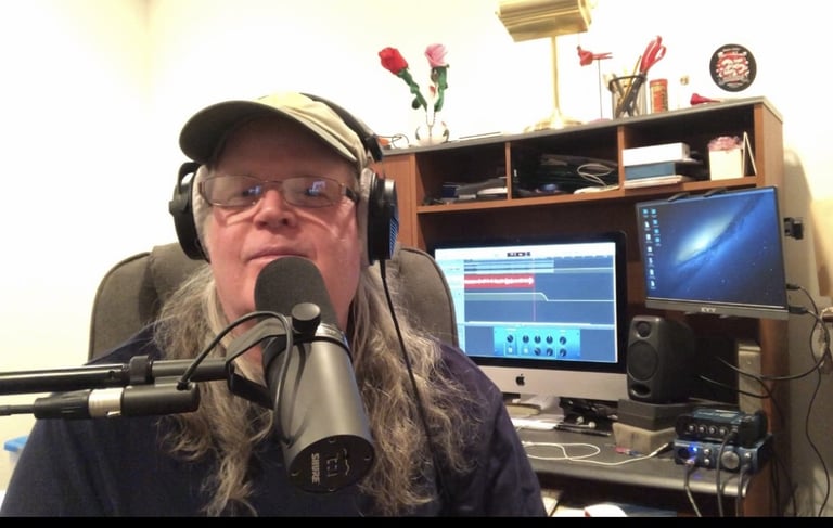 mark glazier (marky) with long hair and glasses on a microphone