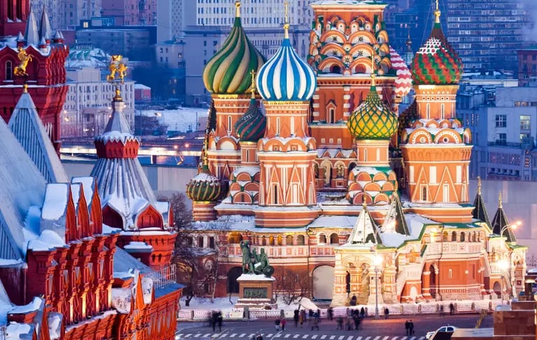 Saint Basil's Cathedral in Moscow's Red Square with colorful onion domes covered in winter snow.