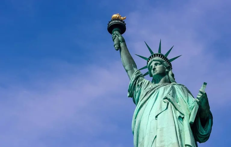 The Statue of Liberty holding her torch against a clear blue sky in New York City.