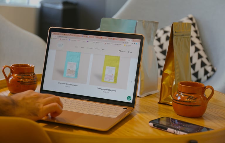 a person sitting at a table with a laptop and a cup of coffee