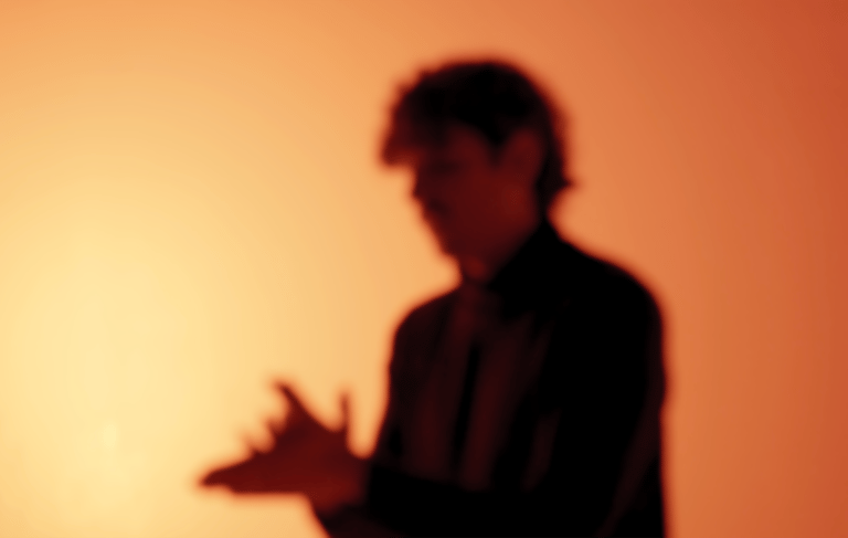 Al-Blanco in a suit and tie is singing a bambera