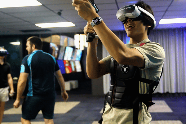 A man in a VR headset and a tacsuit playing a VR game