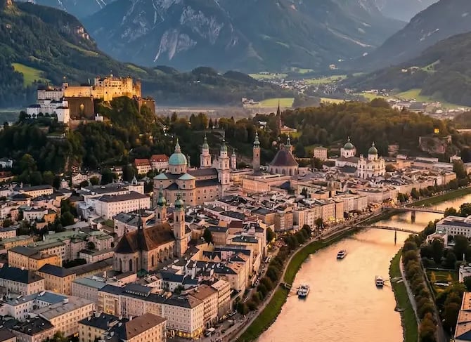 Aerial view of Salzburg old town at sunset with Alpine mountains in the background